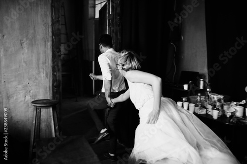 Pre-wedding photoshooting. Hipster blonde bride and groom have fun posing in the loft