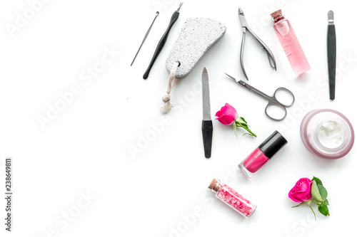 manicure equipment with nail polish and rose petals white background top view space for text