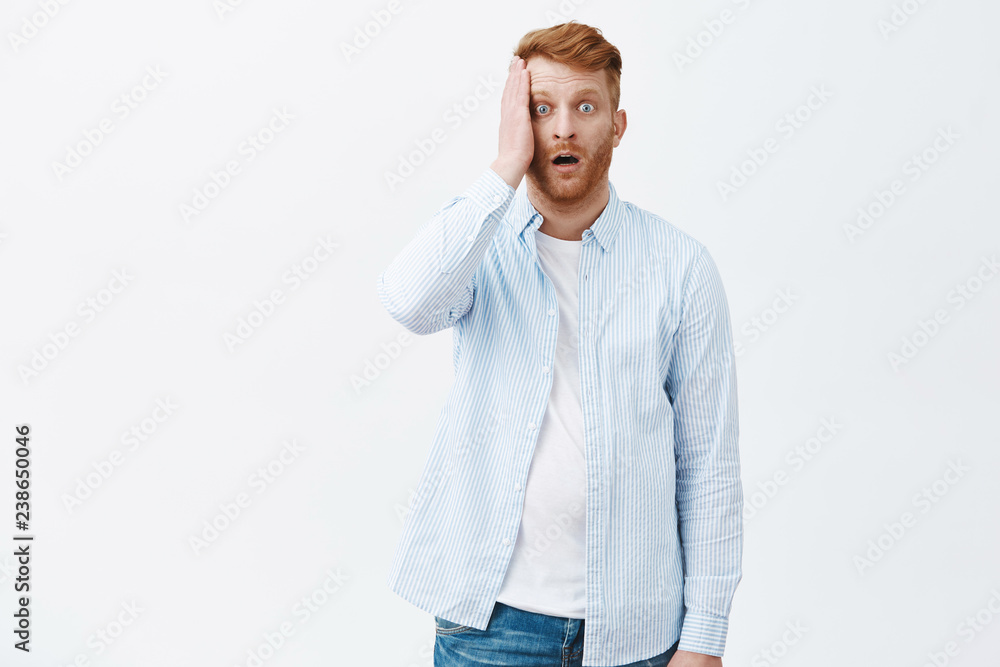 Man lost memory being shocked and in stupor, having no idea what do next. Portrait of devestated stunned mature redhead male in shirt, holding palm on face and dropping jaw from shook Man lost memory being shocked and in stupor, having no idea what do next. Portrait of devestated stunned mature redhead male in shirt, holding palm on face and dropping jaw from shook