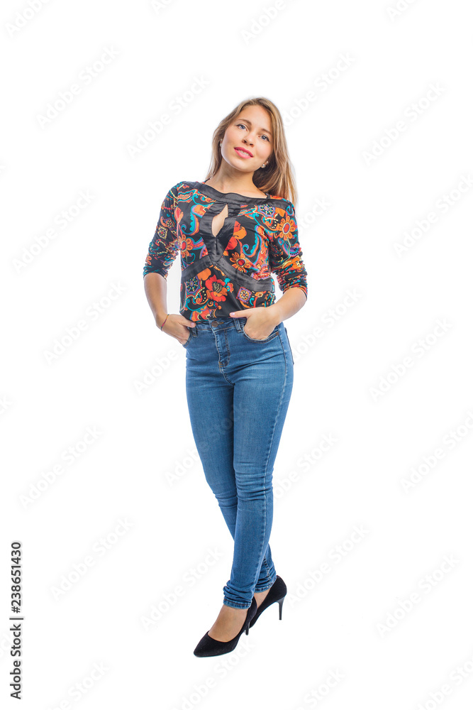 Attractive young woman with long blond hair in jeans, a blouse and shoes posing at the camera with her hands in the pockets of jeans smiling. Attractive young woman with long blond hair in jeans, a blouse and shoes posing at the camera with her hands in the pockets of jeans smiling.