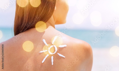 Beautiful Woman with Sunscreen Solar Cream over ocean background