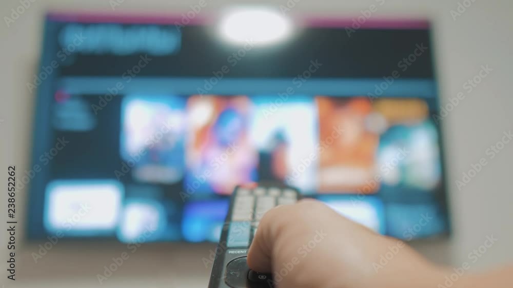 Smart tv with apps and hand. Male hand holding the remote control turn off smart tv . man hand controls TV holding remote. TV concept internet lifestyle online cinema Smart tv with apps and hand. Male hand holding the remote control turn off smart tv . man hand controls TV holding remote. TV concept internet lifestyle online cinema