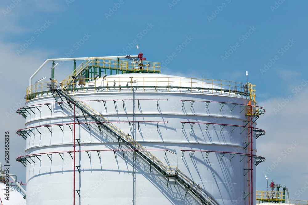 White large storage tanks under a blue sky. Gasoline, oil, chemical or other storage at factory side. White large storage tanks under a blue sky. Gasoline, oil, chemical or other storage at factory side.