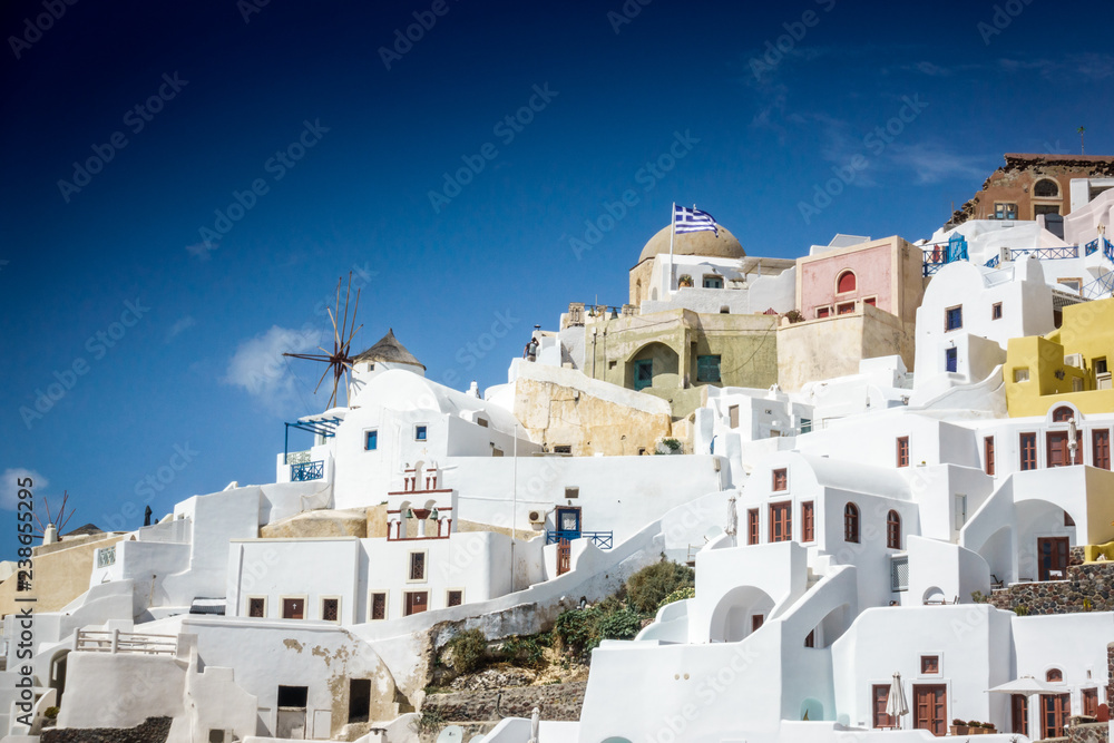 Traditional houses and windmill on the cliff against sky; Santorini; Greece
