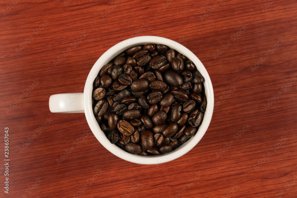 Coffee beans in white cup with wooden background Coffee beans in white cup with wooden background