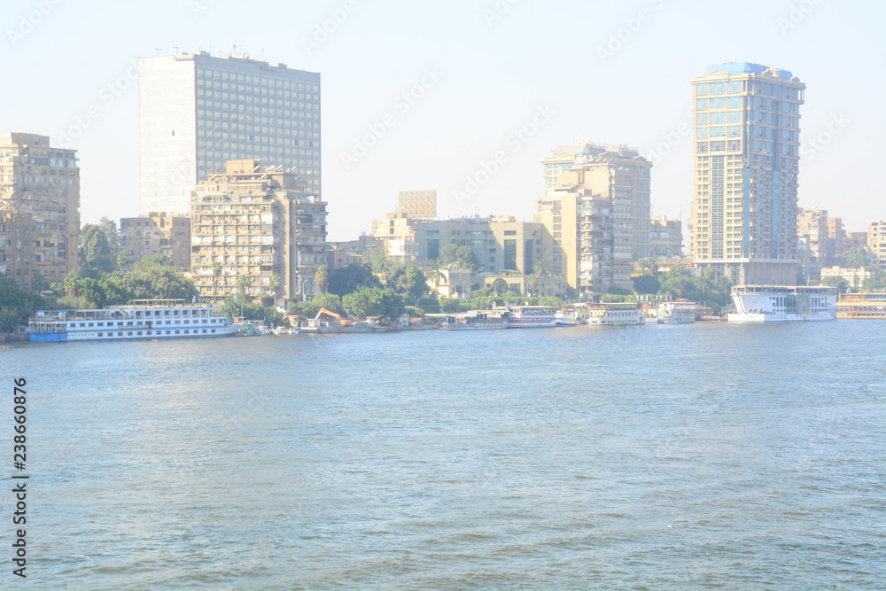  Nile river in Cairo Egypt during the day with boats running and high building surrounding river banks