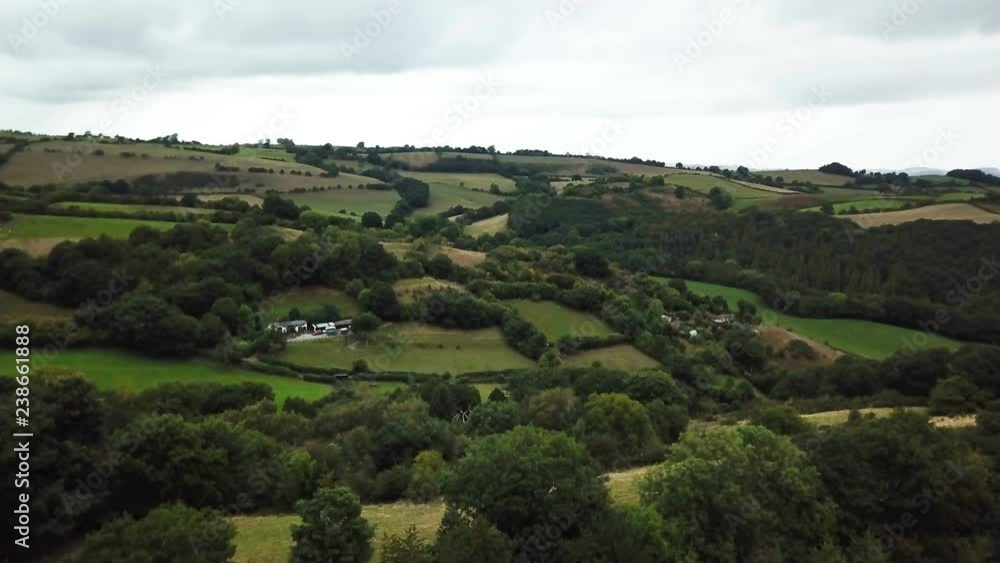 Aerial narrow rural farm valley beautiful Wales. Beautiful green, rock fences, hedgerow and forest tree meadows and rural farms. Rolling hills and gentle valley. Nature and history in harmony. Aerial narrow rural farm valley beautiful Wales. Beautiful green, rock fences, hedgerow and forest tree meadows and rural farms. Rolling hills and gentle valley. Nature and history in harmony.