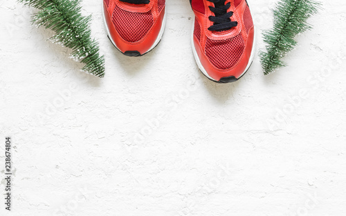 Christmas sport shoes flat lay composition with sneakers, christmas tree on grunge white wood  background. Merry Christmas and Happy new year background special for healthy lifestyle and sport.