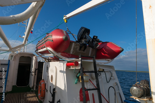 Inflatable boat with a motor on the deck of a ship