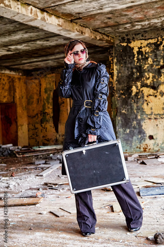 Woman with briefcase standing in abandoned house
