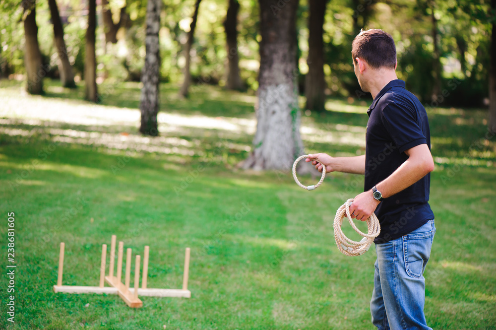Boy playing a game throwing rings outdoors in summer park Stock Photo