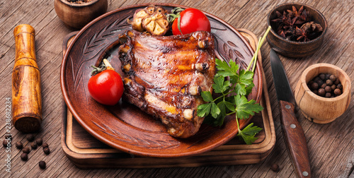 Tasty roasted ribs.Fried pork ribs with tomato on wooden table