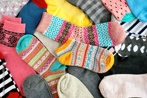 Beautiful multi-colored socks. View from above. Many different socks in the pile. Socks of different sizes are clothes for the feet.