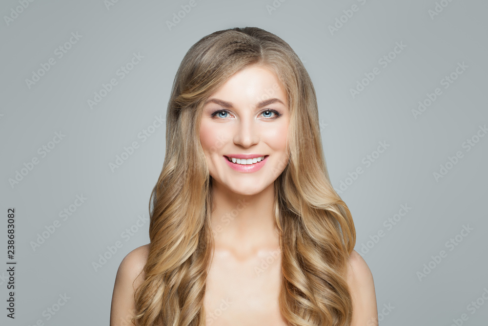 Happy blonde woman with curly hair and clear skin smiling. Facial treatment, haircare and cosmetology concept Happy blonde woman with curly hair and clear skin smiling. Facial treatment, haircare and cosmetology concept