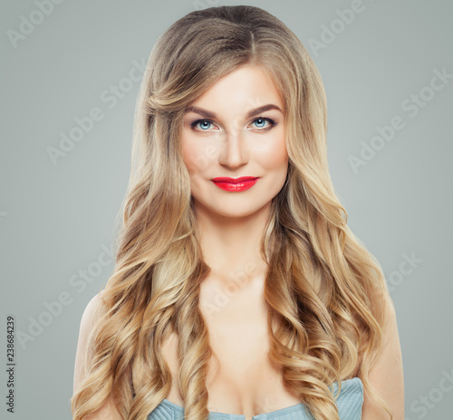Fashion portrait of blonde woman with long fair hairstyle. Red lips makeup, wavy hair