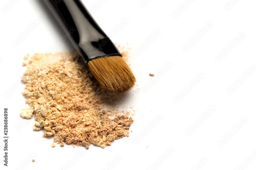 Close-up side view of professional make-up brush with natural bristle and black ferrule with crashed eyeshadow isolated on white background