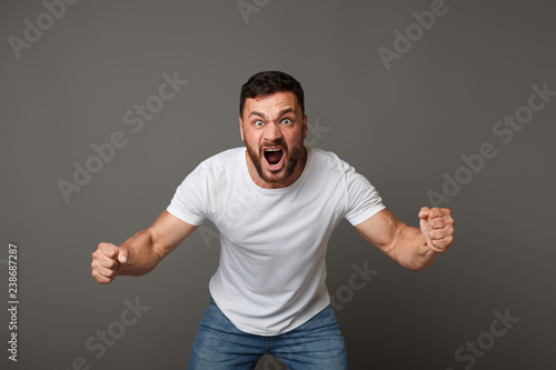 Young angry handsome muscular man screaming loud photo