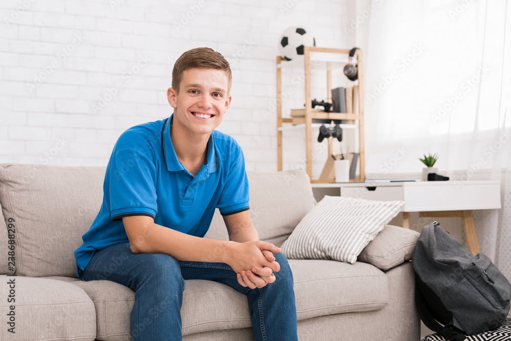 Happy teenager relaxing on sofa in bedroom Happy teenager relaxing on sofa in bedroom