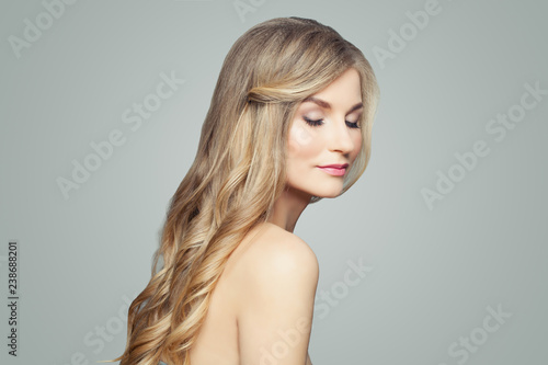 Pretty blonde woman with long healthy hair and clear skin. Facial treatment, spa and cosmetology