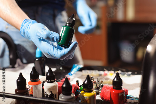 Tableau sur toile Tattoo artist at work. Closeup