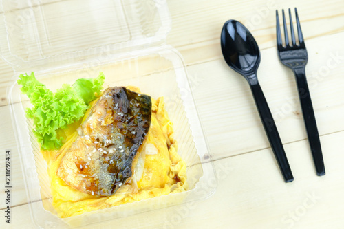 Grilled Teriyaki Saba (Mackerel) on rice in plastic container, on the wooden table ,Topview. photo