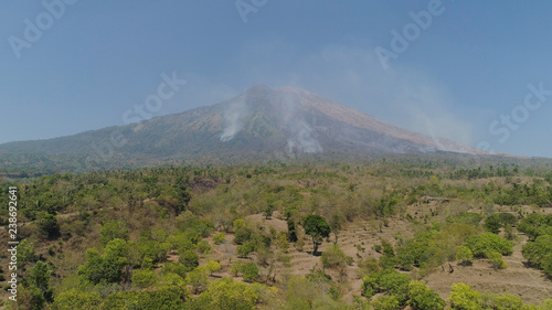slopes volcano with forest fire, farmland at foot of the volcano Agung. tropical landscape aerial view mountains are covered with forest. Bali, Indonesia. © Alex Traveler