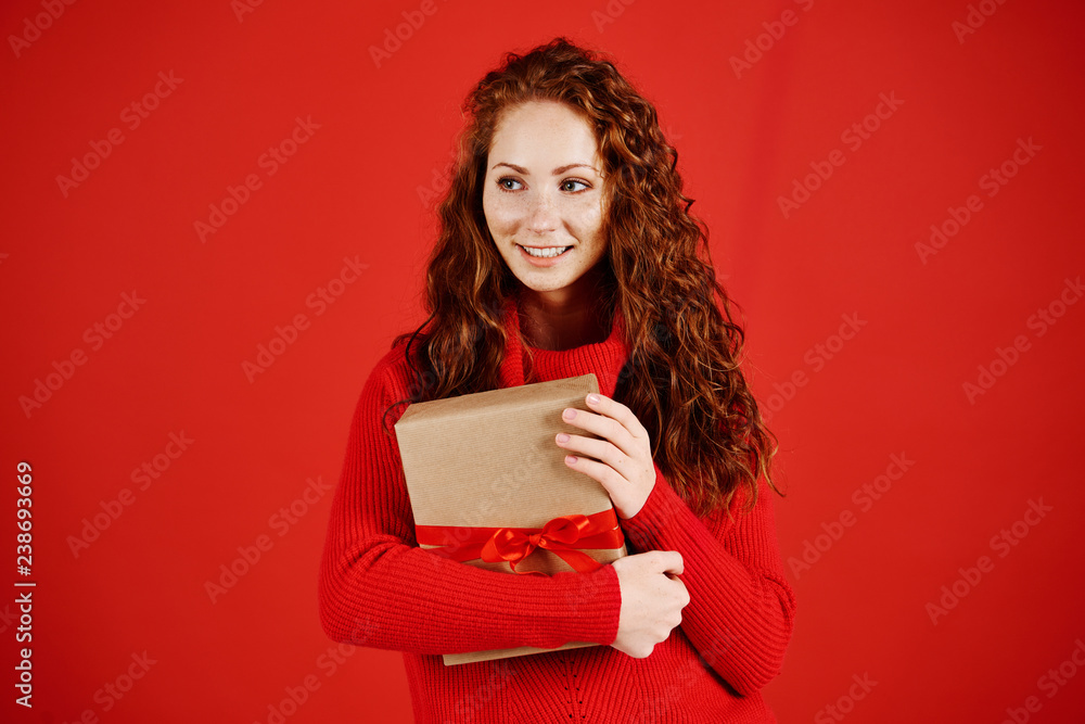 Smiling girl with christmas present looking at copy space Smiling girl with christmas present looking at copy space