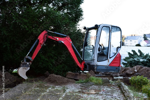 Mini Excavator dug trench in the garden. Works on laying communications.