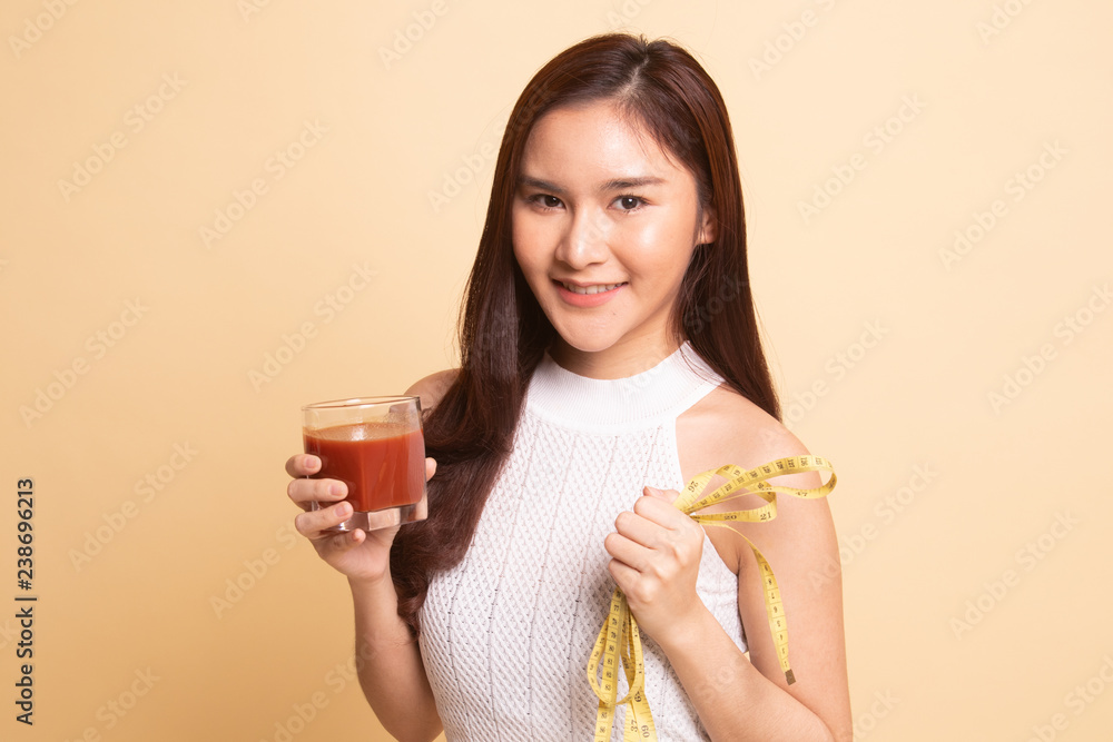 Asian woman with tomato juice and measuring tape. Asian woman with tomato juice and measuring tape.