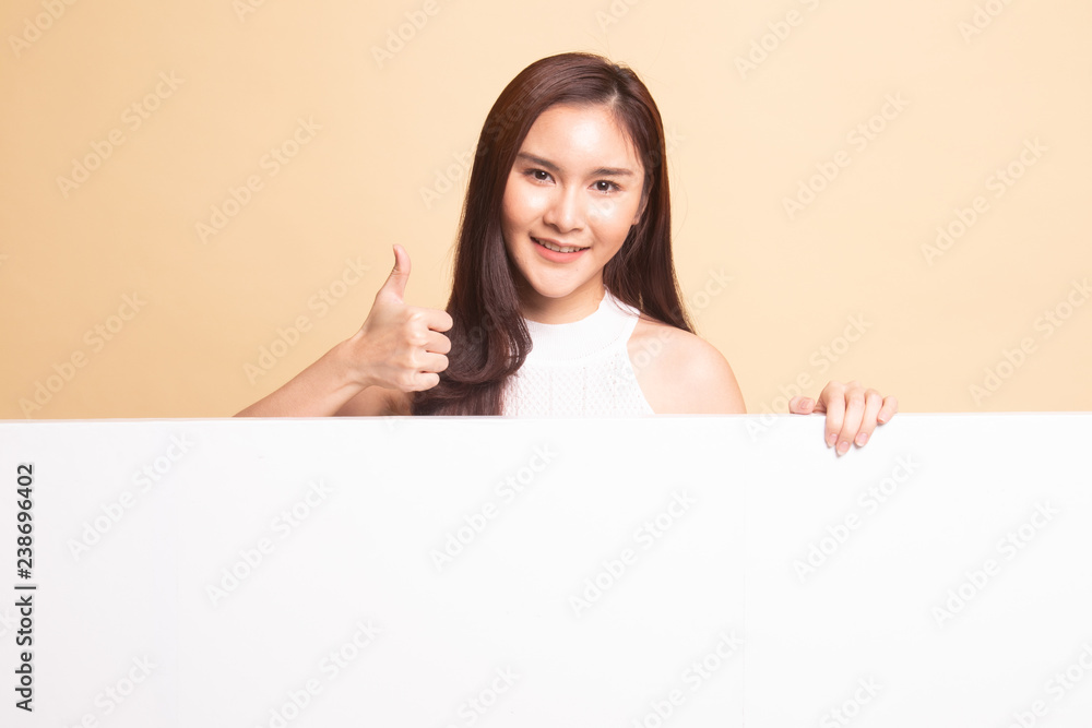 Young Asian woman show thumbs up with blank sign. Young Asian woman show thumbs up with blank sign.