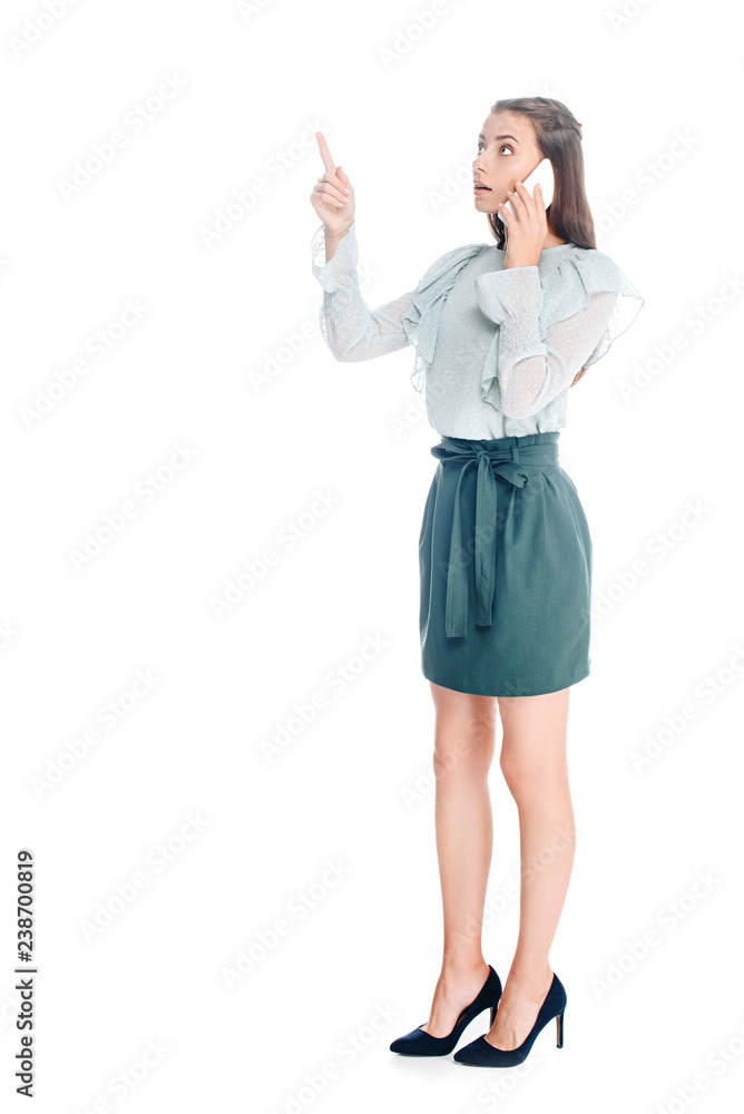 young woman talking on smartphone and pointing away isolated on white young woman talking on smartphone and pointing away isolated on white