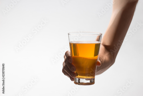 Hand holding glass of craft beer on white background