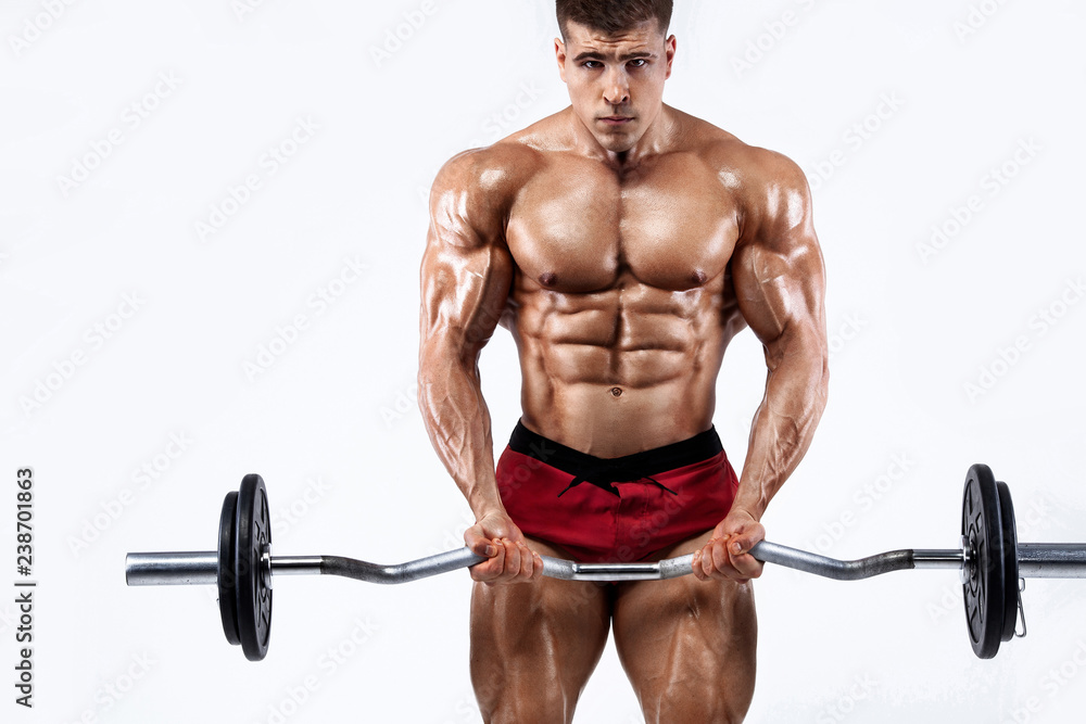 Brutal strong muscular bodybuilder athletic man pumping up muscles with barbell on white background. Workout bodybuilding concept. Copy space for sport nutrition ads. Brutal strong muscular bodybuilder athletic man pumping up muscles with barbell on white background. Workout bodybuilding concept. Copy space for sport nutrition ads.