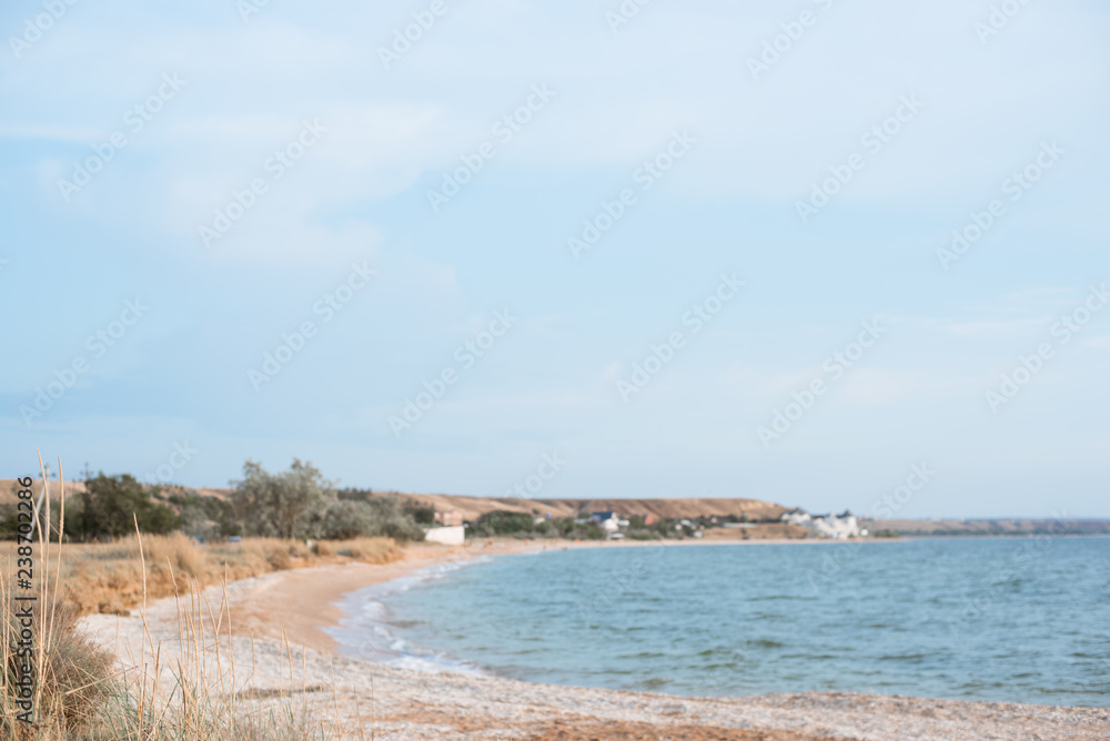 Background of a secluded sandy beach in pastel shades.