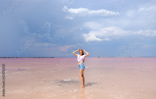 Beautiful blonde girl on a pink lake