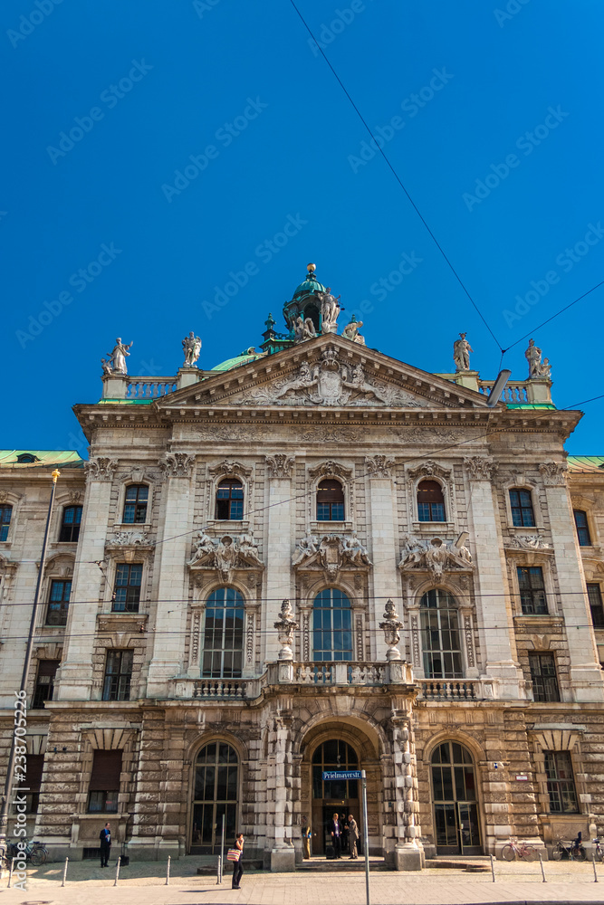 Close view of the southern façade of the Munich Palace of Justice (Justizpalast). The avant-corps is crowned by a gable with the Bavarian coat of arms & on the pediment stands the statue of Justitia.