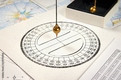 Photography Astrological pendulum for tarot and astrological circle on the background of ast