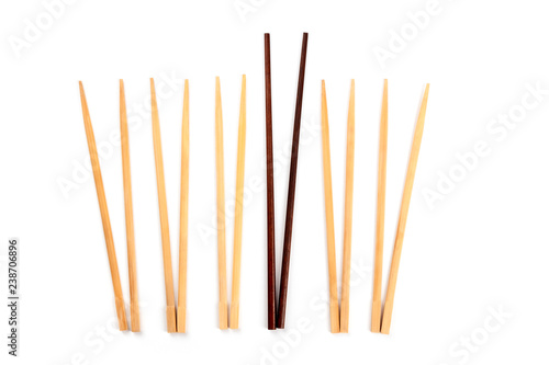 Many pairs of chopsticks on a white background with one of them obviously larger and better than the others. A concept of individuality, leadership, dominance, mastery etc photo