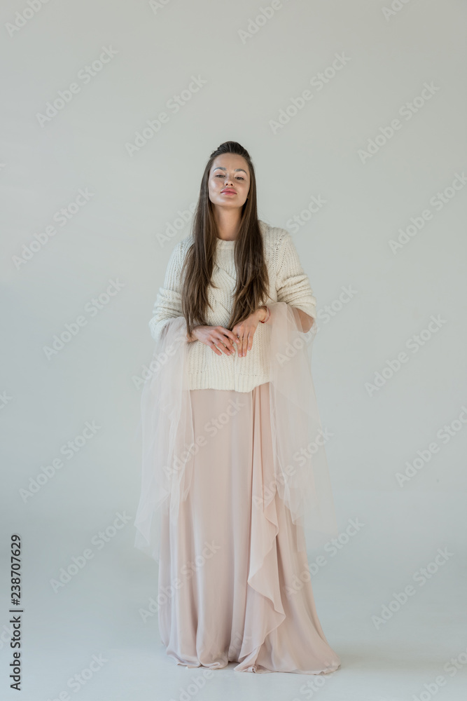 attractive woman in fashionable winter sweater and skirt standing isolated on white attractive woman in fashionable winter sweater and skirt standing isolated on white