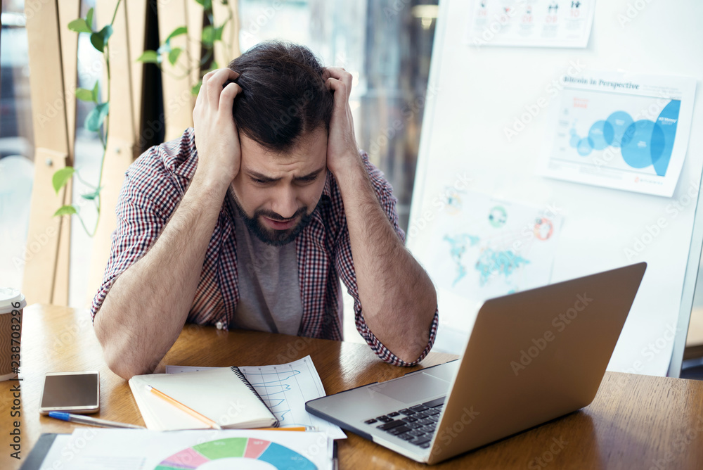 Man sitting at the table at creative stylish office stressful wo Man sitting at the table at creative stylish office stressful wo
