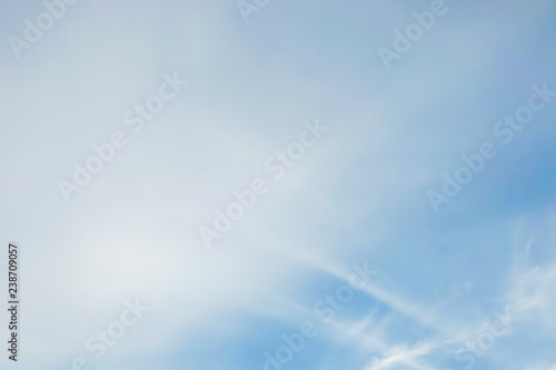 blue sky with white soft clouds, blurry image.