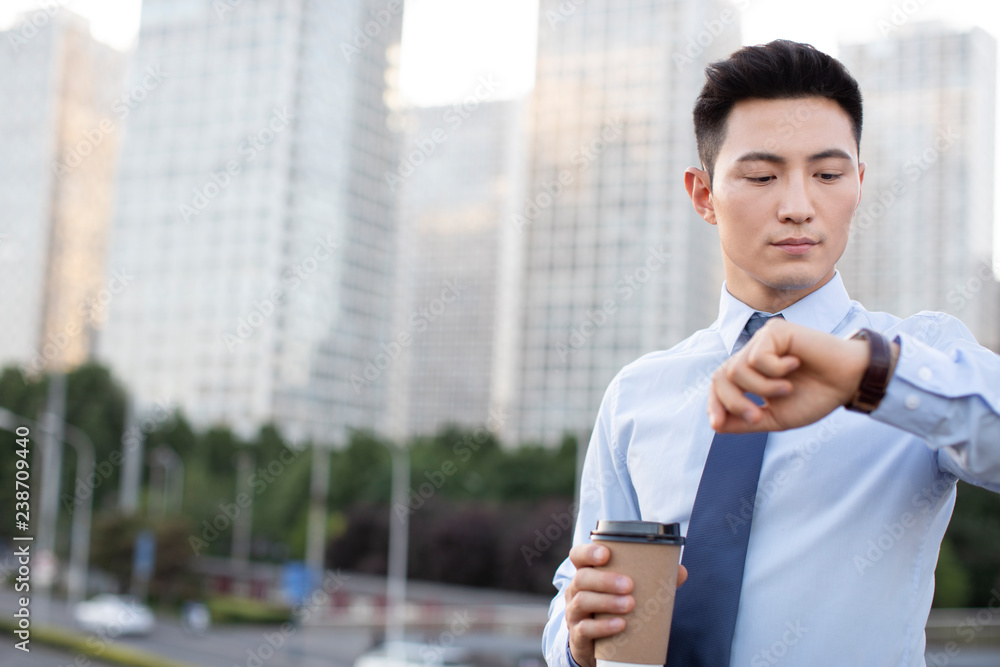 Confident young businessman checking the time Confident young businessman checking the time