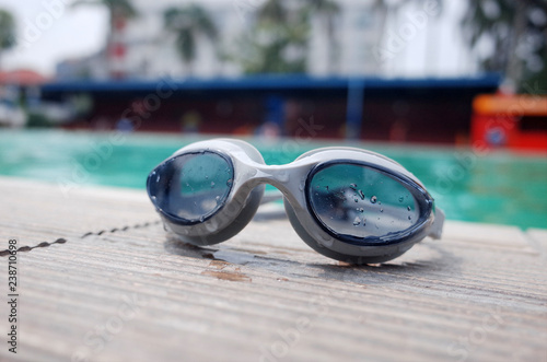 Swimming goggles on the floor near the swimming pool