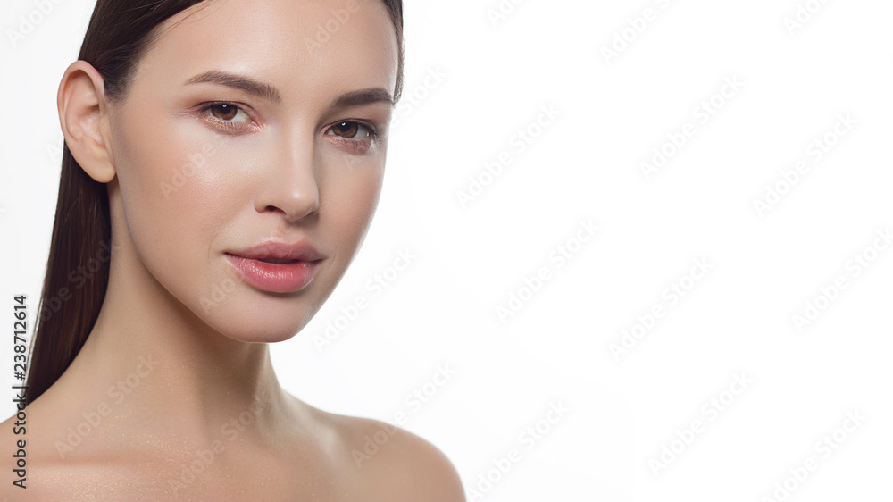 Fototapeta premium Closeup portrait of a woman with developing straight hair. Sweet tender young girl brunette. Natural lipstick, transparent clean skin. Skin care natural cosmetics in the spa salon or cosmetology.