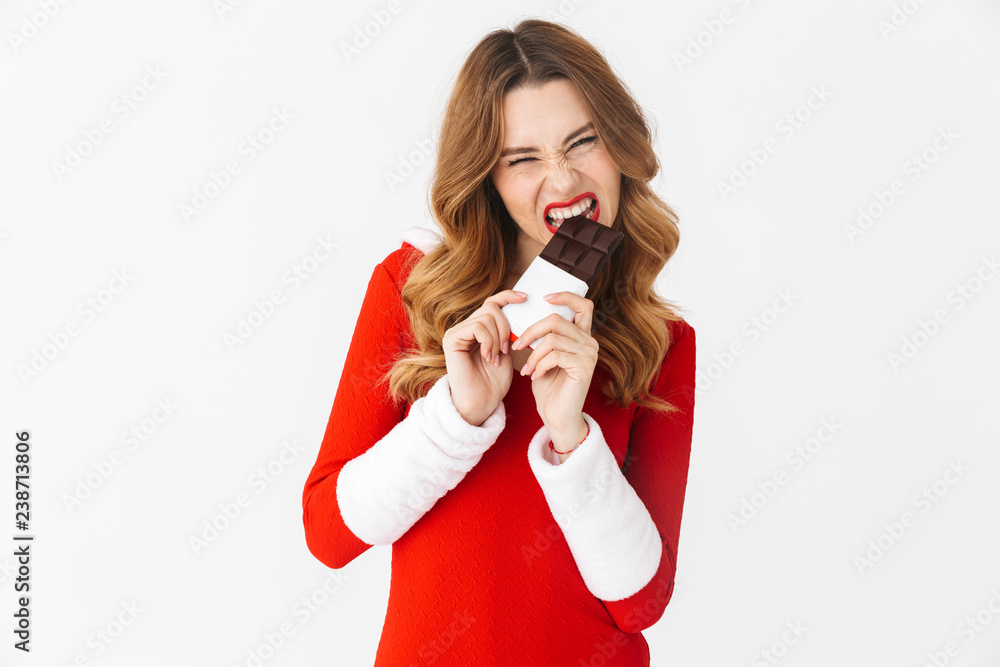 Φωτογραφία Portrait of european woman 20s wearing Santa Claus red costume smiling and eatin