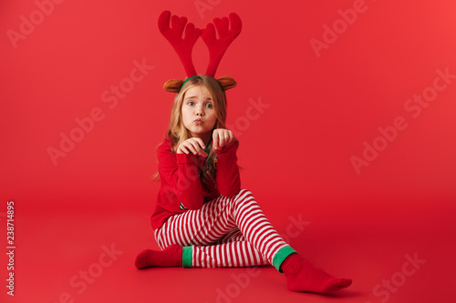 Cheerful little girl wearing Christmas raindeer costume