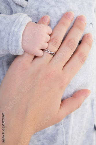 Hand newborn sleeping baby in the hand of mother close up