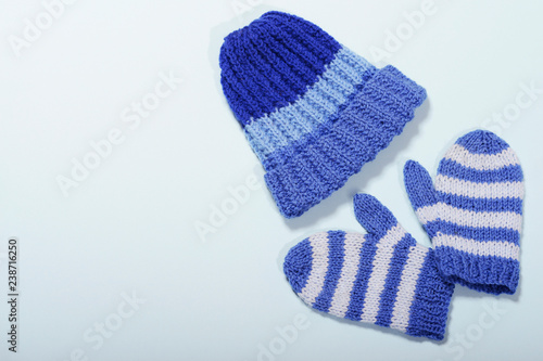  knitted blue hat and mittens for a boy on a blue background are made with their own hands needlework knitting wool product