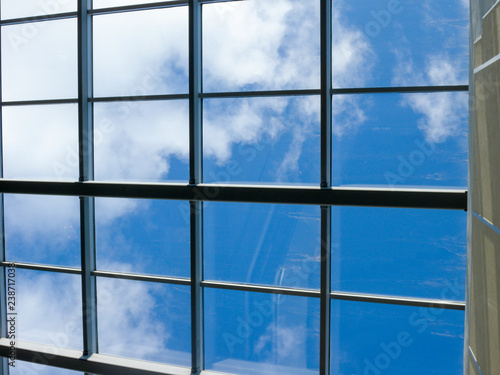 Blue sky with white clouds through the window in the ceiling of a large building