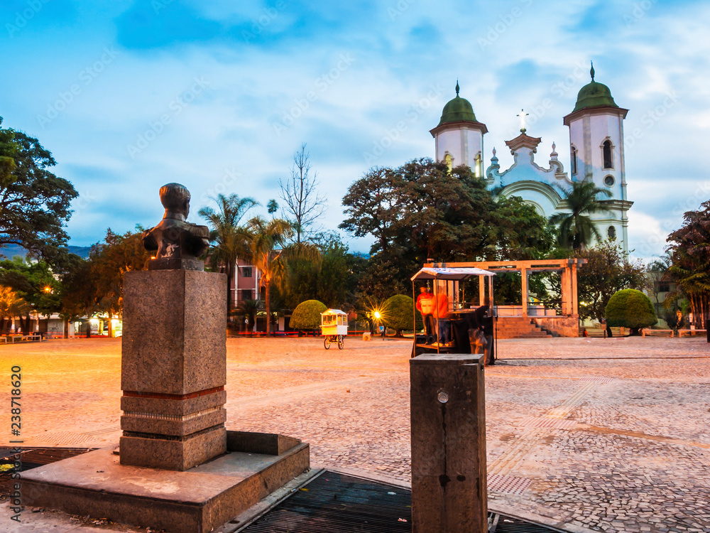 Statue, bandstand and church in square at dusk Statue, bandstand and church in square at dusk